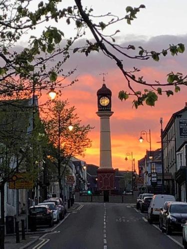a clock tower in the middle of a street at sunset at Bedwellty Lodge near BikePark Wales in Tredegar