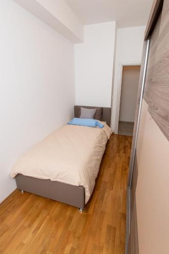 a bed in a small room with a wooden floor at Luxury Apartments Valentino in Ohrid