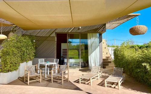 a patio with a table and chairs under an umbrella at Villa Jardins D'Isa in Marrakech