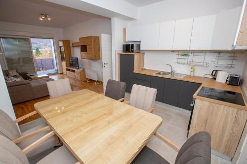 a kitchen and dining room with a wooden table and chairs at Luxury Apartments Valentino in Ohrid