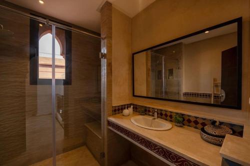 a bathroom with a sink and a shower and a mirror at Villa Leya - Piscine chauffée in Marrakech