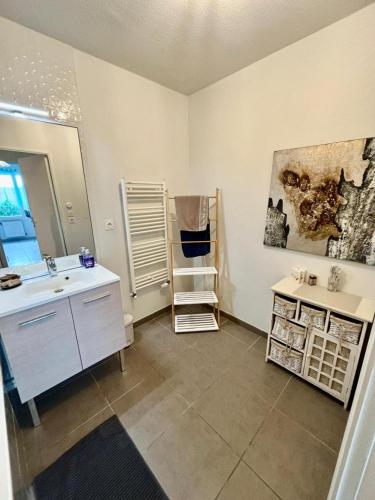 une salle de bain avec un lavabo et un miroir dans l'établissement 3 chambres, métro tram à 50 m, parking privé !, à Vaulx-en-Velin