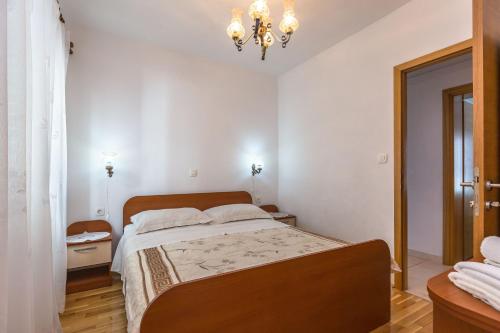 a bedroom with a bed and a chandelier at Apartments and Rooms Happiness in Tučepi