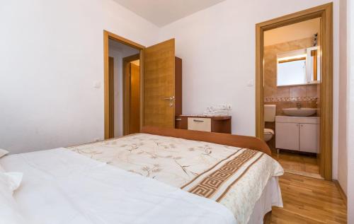 a bedroom with a bed and a bathroom with a sink at Apartments and Rooms Happiness in Tučepi
