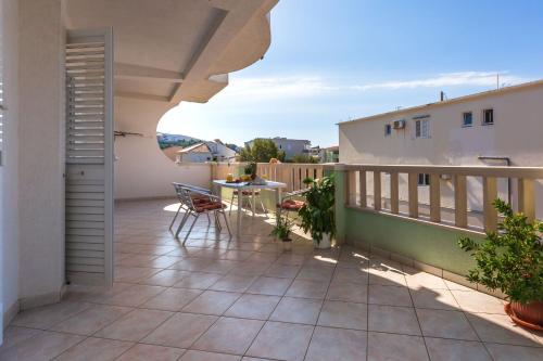 a patio with a table and chairs on a balcony at Apartments and Rooms Happiness in Tučepi
