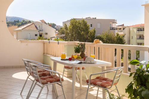a balcony with a table and chairs on a balcony at Apartments and Rooms Happiness in Tučepi