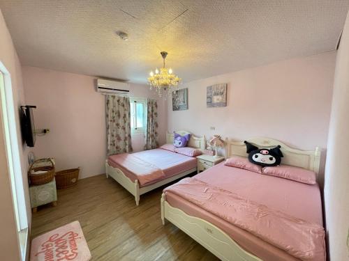 a bedroom with two beds and a chandelier at Traveler's journey in Hsi-lo