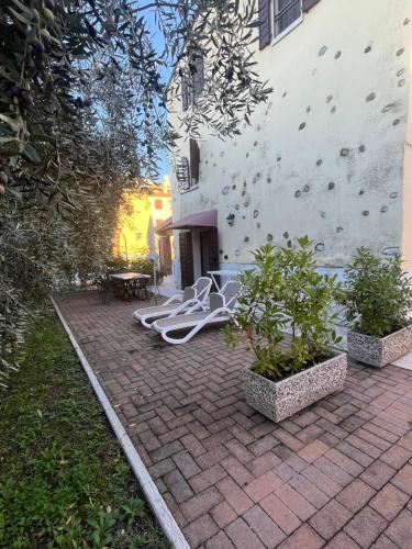 a brick patio with a white hose next to a building at Apartments Colombara Bardolino in Bardolino