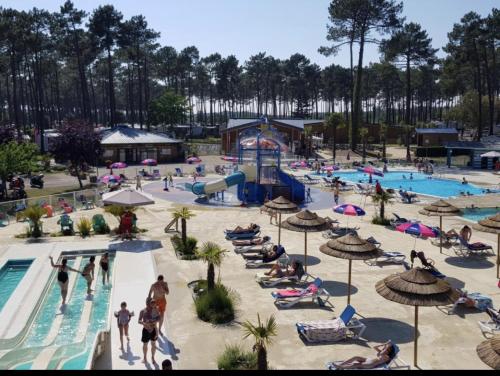 a group of people at a swimming pool at a resort at Les dunes de Contis Chez Edith océan pins et détente assurée dans camping 4 étoiles in Saint-Julien-en-Born