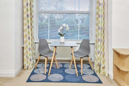een tafel en twee stoelen voor een raam bij Host & Stay - Thamesview in Staines