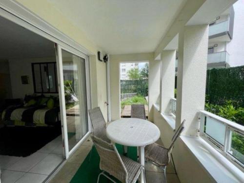 a room with a balcony with a table and chairs at 3 chambres, métro tram à 50 m, parking privé ! in Vaulx-en-Velin