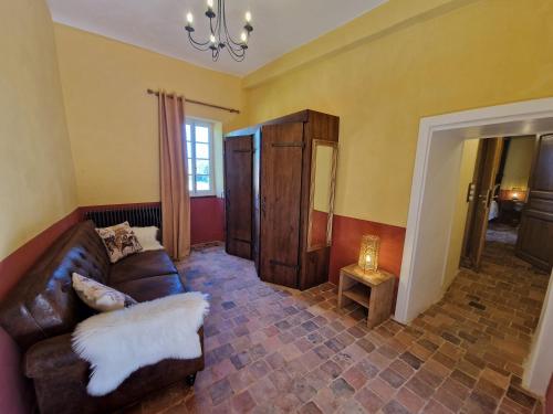 a living room with a leather couch and a table at Château de la Mothe de Vicq - Allier, à proximité de Vichy in Vicq