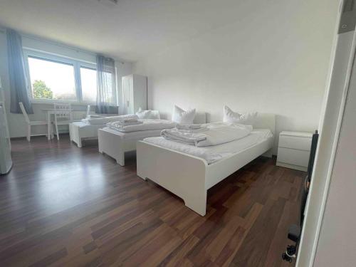 Habitación con 2 camas y suelo de madera. en SAD163 - Möblierte Monteurwohnung mit Balkon, en Schwandorf