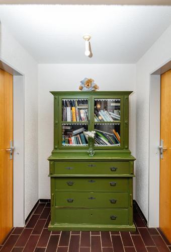 a green dresser with books on it in a room at Naturfreundehaus Brend in Neuweg