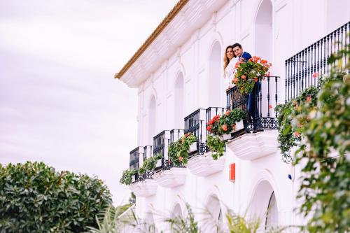 a couple standing on a balcony of a building at Hotel Albaida Nature in Mazagón