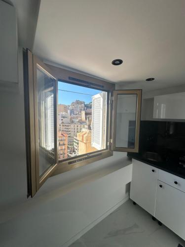 a kitchen with a large window with a city view at Studio confort Business 20m2 - 2 min a pied de Monaco in Beausoleil