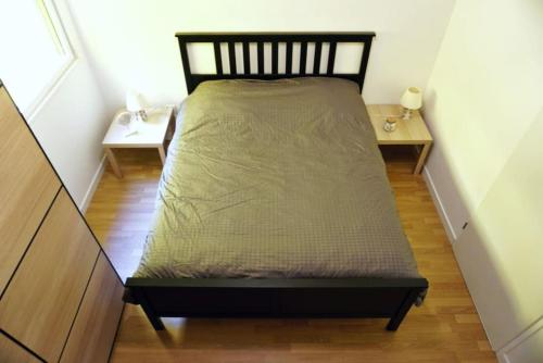 - un lit dans une petite chambre avec 2 tables dans l'établissement Chez Pascal Sissi -New Appart, Ile Nantes, CCgrés, à Nantes