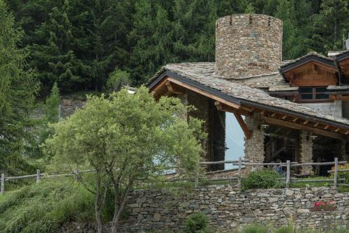 a stone house with a chimney on top of it at Agriturismo Plan de la Tour B&B in Cogne