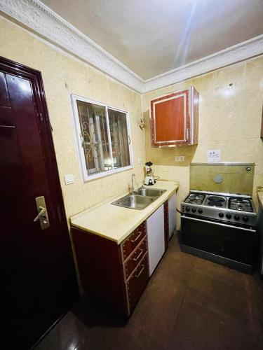 a small kitchen with a sink and a stove at Maitama Apartment in Abuja