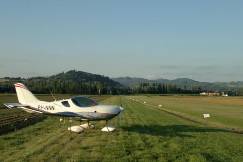 a small plane parked in a grass field at Villa Illuminata by MMega in Calzolaro