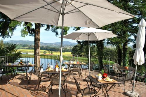 a patio with tables and chairs and umbrellas at Villa Illuminata by MMega in Calzolaro