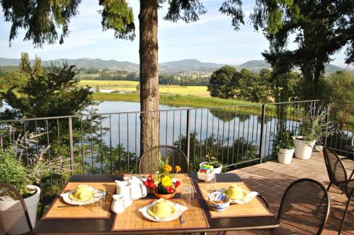 a table on a patio with a view of a lake at Villa Illuminata by MMega in Calzolaro