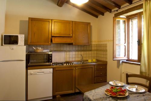 a kitchen with wooden cabinets and a white refrigerator at Villa Illuminata by MMega in Calzolaro