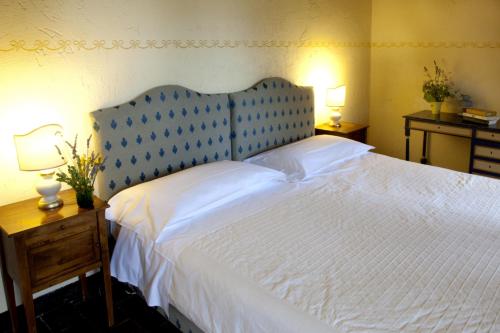a bedroom with a large white bed with a blue headboard at Villa Illuminata by MMega in Calzolaro