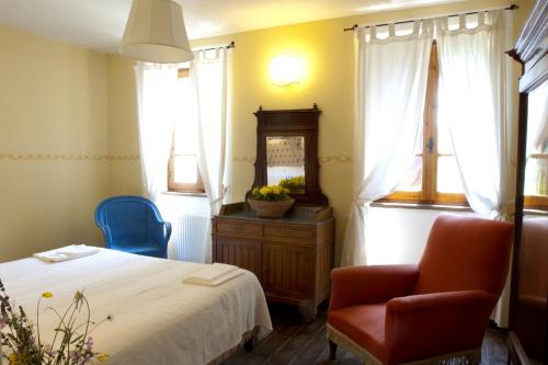 a bedroom with a bed and a chair and a mirror at Villa Illuminata by MMega in Calzolaro