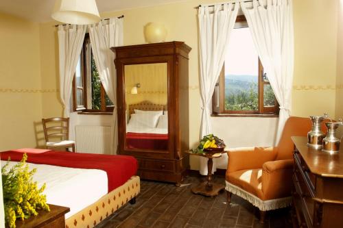 a bedroom with a bed and a chair and a mirror at Villa Illuminata by MMega in Calzolaro