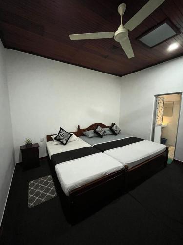 a bedroom with a bed with a ceiling fan at Villa Beach Heaven in Hikkaduwa