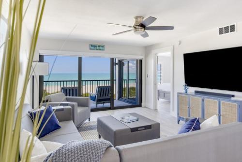 Una sala de estar con un televisor grande y un sofá. en Pelicans Roost 307 condo, en Sanibel