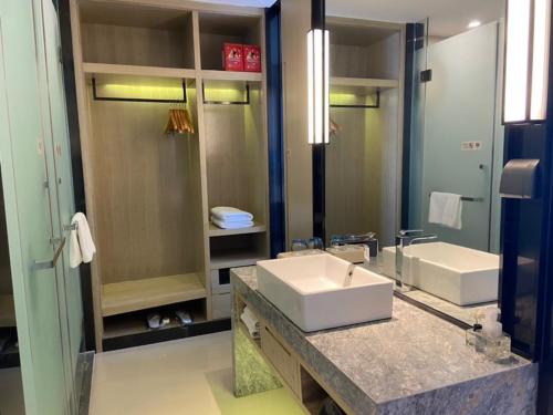 a bathroom with a sink and a large mirror at Echarm Hotel Nanchong Taihe Center Nanchong Railway Station in Nanchong