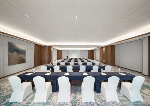 a conference room with a large table and white chairs at Holiday Inn Hangzhou GCEC in Hangzhou