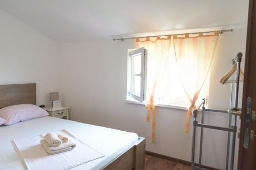 a bedroom with a bed and a window with towels at Rooms Sunny valley in Krupa