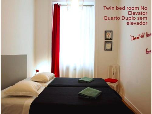 a bedroom with a bed with a red curtain and a window at Living Lounge Hostel in Lisbon