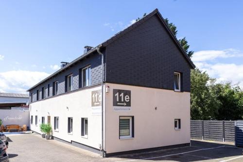a large white building with a black roof at Ferien-Monteurwohnung NOM App2 Sky Terrasse High End in Northeim