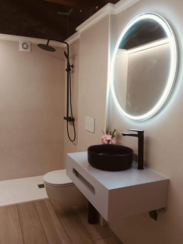 a bathroom with a black sink and a mirror at Quinta Pazo Corisca in Salceda