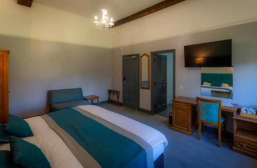 ソーンベリーにあるThornbury Lodgeのベッドと机と机があるホテルの部屋