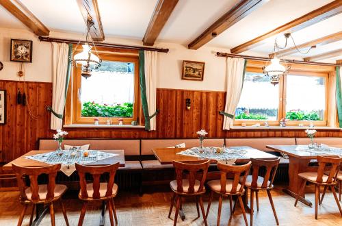 a dining room with tables and chairs and windows at Naturfreundehaus Brend in Neuweg
