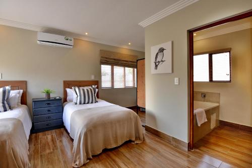 a bedroom with two beds and a mirror at Thanda Manzi Country Hotel in Centurion