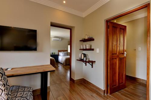 a living room with a couch and a television on a wall at Thanda Manzi Country Hotel in Centurion