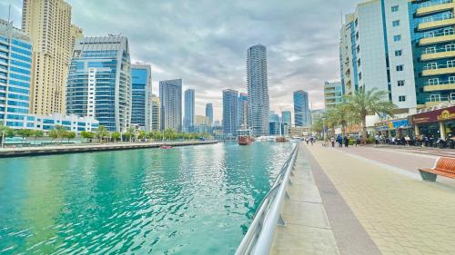 a river in the middle of a city with tall buildings at Marina Comfort Room with Bath inside in Dubai