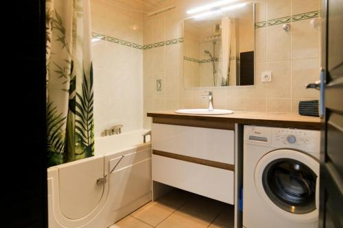 une salle de bain avec une machine à laver et un lavabo dans l'établissement Appartement avec superbe vue sur le port de plaisance des Sables d'Olonne - 4 personnes, à Les Sables-dʼOlonne