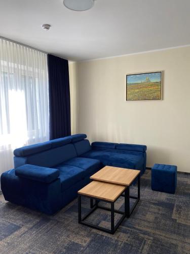 a living room with a blue couch and a coffee table at Dom Pielgrzyma ARKA in Licheń Stary