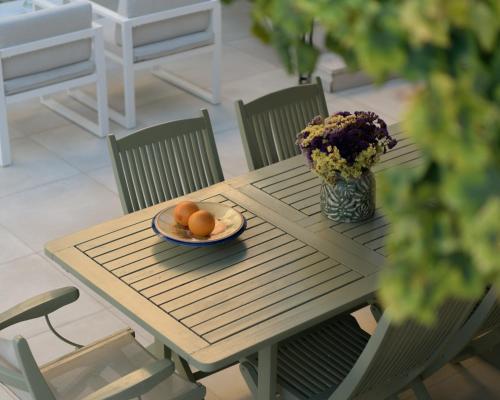 a table with a plate of oranges and a vase of flowers at The Artemis Home, pure rustic romance, By ThinkVilla in Astérion