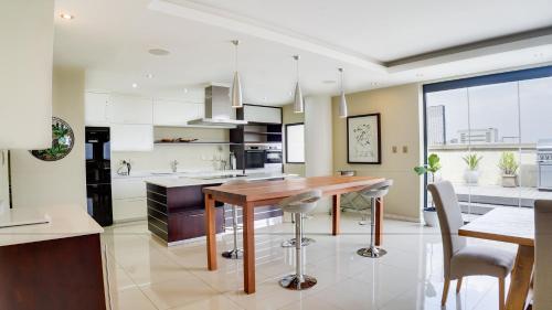 a kitchen with a wooden table and chairs at 4 on Pritchard Luxury Suites in Johannesburg