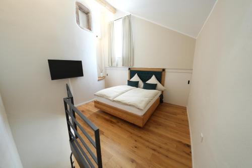 een kleine slaapkamer met een bed en een raam bij Charmantes Chateau Lichter - Alte Schmiede in Ließem