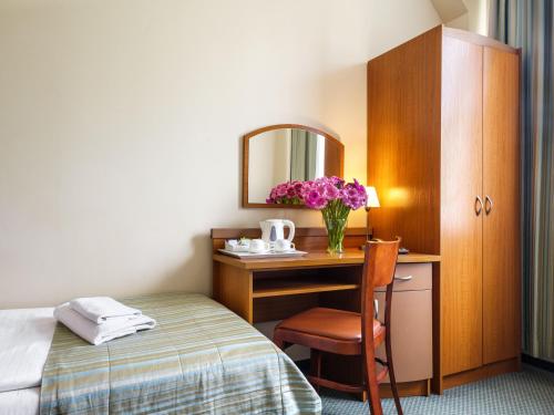 クラクフにあるHotel Galicyaのベッドと鏡付きの机があるホテルの部屋