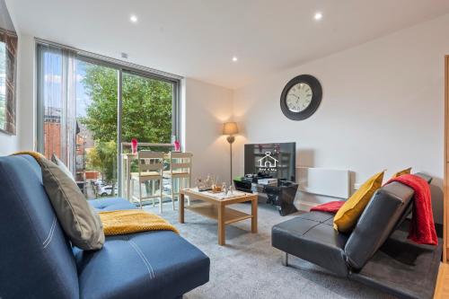 a living room with a blue couch and a table at Heart of City Centre Luxury Apartment with Secure Underground Parking in Birmingham